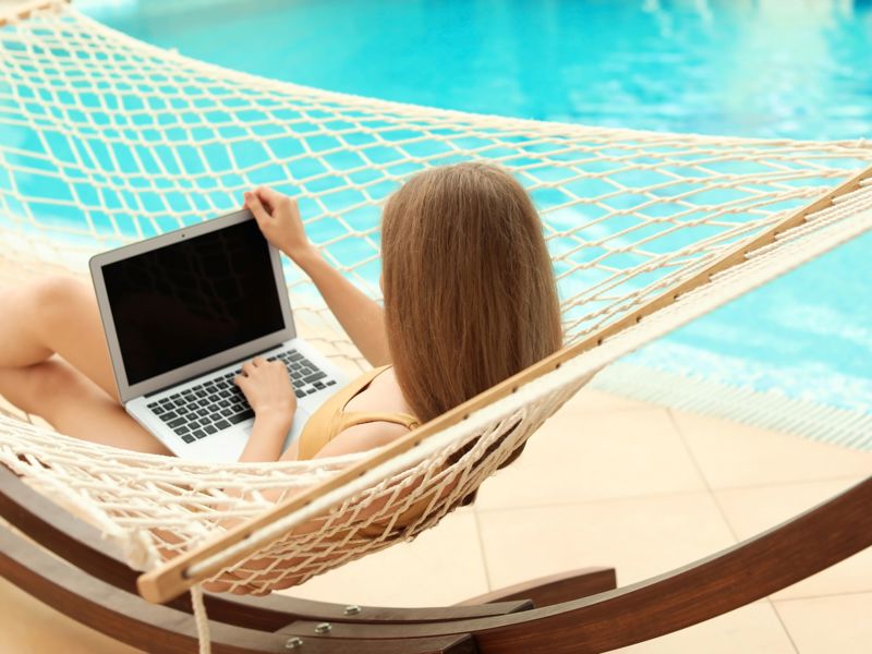 woman by pool using laptop