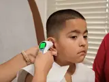 Nurse obtains a boy's temperature