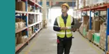 A man holding a laptop inside of a warehouse